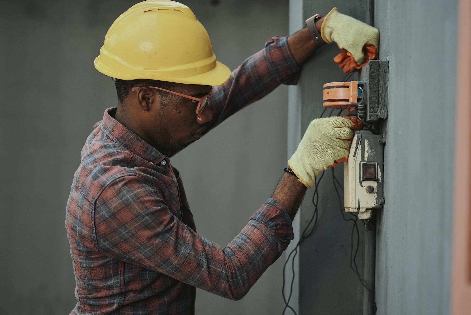 A man inspecting a service panel with a whole-house surge protector installed.
